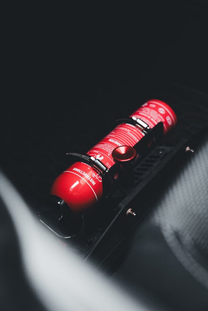 A detailed shot of a red fire extinguisher securely mounted inside a vehicle, emphasizing safety equipment.